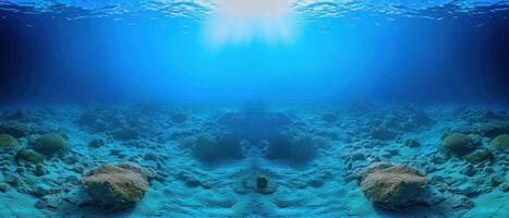 looking up at a sandy ocean floor with rocks, and deep blue sea water, photo