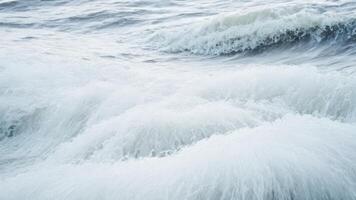 water foaming up onto shore with little waves, photo