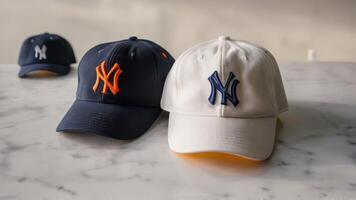 hats one with the yankees logo are sitting on a marble counter, photo