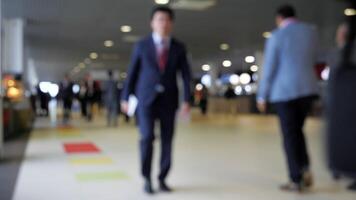 Blurry view of businessmen walking in lobby. Media. A lot of businessmen are walking through lobby of business center. Businessmen in suits walk down hall video
