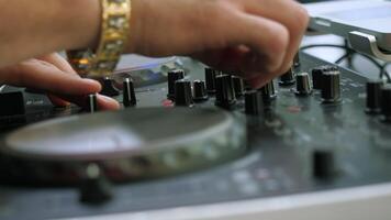 Close-up of man playing on dj console. Media. Man turns buttons on music console. DJ plays new music console at disco video