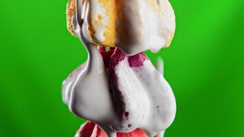 Close up of a lot of small meringues on a green chroma key background. Stock clip. Pouring white glaze on colorful meringue cakes, concept of confectionery. video
