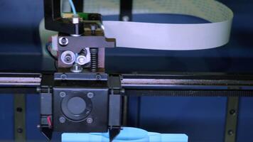 Close-up of moving machine in 3d printer. Media. Creating objects on 3D printer with machine. Process of operation of 3d printer machine during printing video