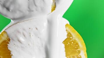 Close-up of citrus fruits with white paint. Stock clip. with citrus fruits and flowing white liquid. Creative with fruit and white cream on green background video
