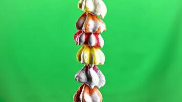 Colorful little bizet. Stock footage.A small neat crunchy cookie on a green background that stands on top of each other and which is poured with sugar syrup video