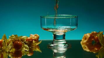 A bright illuminated still life. Stock clip . A beautiful roomy mug in which brandy is poured and small oranges and tangerines lie next to it. video