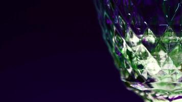 Soft drink of green color on blurred colorful wall background. Stock clip. Soda with bubbles in transparent glass. video