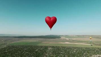 View of the green mountains. Shot. Drone view of the beautiful bright fields where huge parachutes in the shapes of hearts fly. video