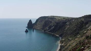 A beautiful bird's-eye view of the landscape. Action . A view of the blue ocean, mountains and green trees standing on them and you can see small sails that float near the shore. video