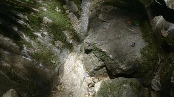 A large stream of water in the mountains. Creative.A long stream gushing in the stone rocks of gray color. video