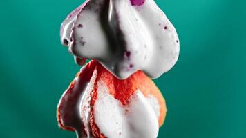Colorful cookies in liquid cream. Stock clip. White cream flows down colorful cookies. Creative with sweets and chromakey video