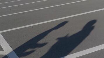 Two contracting shadows. HDR. Two shadows on asphalt are talking and gesticulating. Shadows on road talk negotiate. Business or crime video