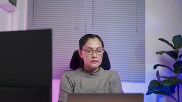 Woman wearing glasses looking at large digital glitch screen while displaying lines of code. Professional hackers break into cyber security defenses. video