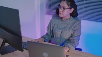 Female programmer working and big computer screen showing lines of programming language code. Portrait of a woman creating software video