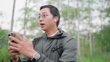Phone or people having trouble connecting in the forest, errors, reception failures, smartphones, stress, hiking trail problems. A man asks for help carrying a backpack while walking in the forest. video