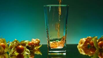 Beautiful drink is poured into transparent glass. Stock clip. Bright drink is poured into glass on background of ingredients. Fruit around glass with drink on isolated background video