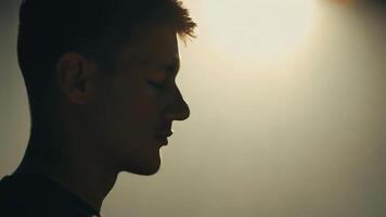 A closeup of a young mans face his eyes closed in concentration as he meditates a serene look of peace and contentment on his face showcasing his passion for mindfulness and. video