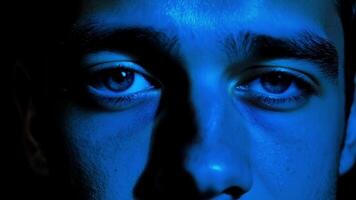 A closeup of a young mans face his vibrant blue eyes reflecting the admiration and respect he feels towards someone.. video