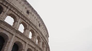 Italy, Rome - July 29, 2022. Bottom view of Roman architecture of Colosseum. Action. Part of Colosseum on background on sky. Beautiful architecture of famous and recognizable Colosseum in Rome video