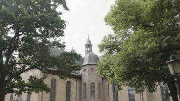 Norway, Oslo - July 20, 2022. Ancient cathedral with green trees. Action. Picturesque view through green trees of cathedral. Lutheran Church in Norway video