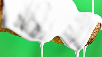 Sweets in white cream. Stock clip. Dripping white liquid on baking. Baking with liquid dripping cream. Close-up of cream bun on green background video