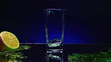 Blue background with a drink . Stock clip . A bright background on which tarragon is poured and a lemon with a fir branch lies next to it. video