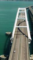 Big bridges over the sea. Shot.A helicopter view where two large bridges for cars are located above the sea where ships float and cities on the coast are visible from behind. video
