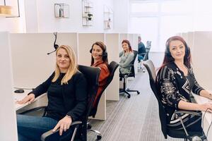 Team of Women Providing Customer Support in Call Center Environment. photo