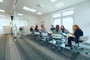 Diverse Business Team Discussing Projects in a Modern Glass Office. photo