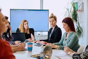 Diverse Business Team Discussing Projects in a Modern Glass Office. photo