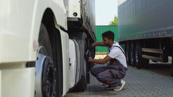 Indian truck driver using socket wrench while changing tire on the road video