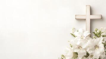 Composition with a Christian wooden cross and flowers against muted white background with space for text. Funeral invitation template photo