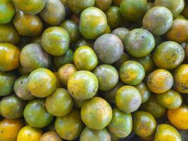 Green oranges Pile. A pile of various green oranges with various green colors is on display at the local farmer's market. photo