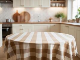 Empty round table with beige and white checkered tablecloth top on blur kitchen background photo