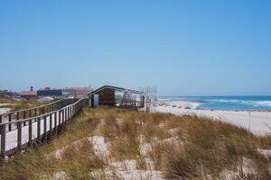 Serene Beach Scene with Boardwalk and Red-Tiled Roofs in Aveiro, Portugal photo