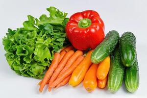 A colorful mix of fresh vegetables arranged on a white background photo