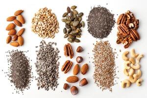 An assortment of nuts and seeds spread out on a white background photo