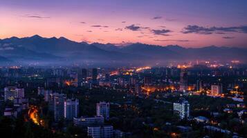An expansive view of Almaty's cityscape at dusk with vibrant lights and mountains visible. photo