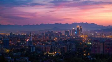An expansive view of Almaty's cityscape at dusk with vibrant lights and mountains visible. photo
