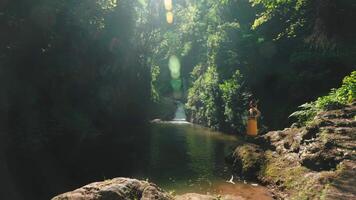 Tranquil River with Waterfall and Traditional Attire video