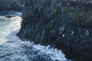 Dramatic Basalt Cliffs and Ocean Waves at Arnarstapi, Iceland Coastline photo