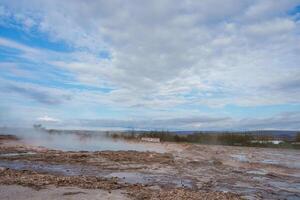 Steaming Hot Springs and Rocky Terrain at Geysir Center in Iceland photo