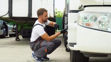 Professional mechanic using socket wrench while changing truck tire on car service video