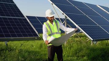 Indian engineer checks the design documentation of the solar station. video