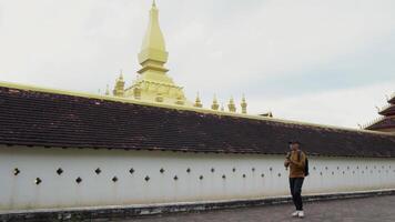 A Male tourist visits Pha That Luang in Laos. which is the concept of local cultural tourism in Southeast Asia video