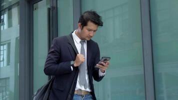 Businessman carrying bag and talking on phone while traveling to work. Concept of using technology in business while traveling. video