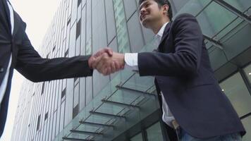 Asian businessman showing smile and joy in shaking hands with business partner, concept of cooperation to make business successful and having connection to connect business to success. video