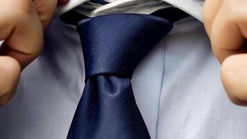 A silk tie with a subtle pattern being straightened, emphasizing meticulous appearance. video