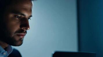 A business professional's face illuminated by the glow of a computer screen, focused on their work. video