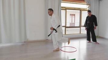 zwei Männer Zug mit Springen Hindernis Übungen während Karate Ausbildung im Fitnessstudio video